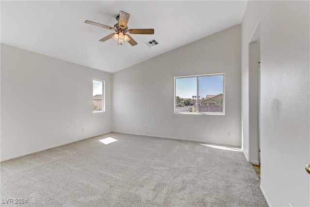 unfurnished room featuring lofted ceiling, a ceiling fan, visible vents, and light colored carpet