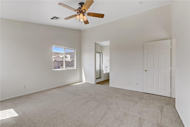 unfurnished bedroom featuring baseboards, visible vents, a ceiling fan, connected bathroom, and light colored carpet