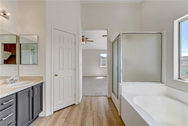 full bath featuring vanity, wood finished floors, a shower stall, and a bath