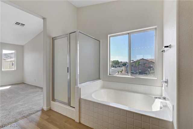 full bathroom featuring a stall shower, visible vents, a bath, and wood finished floors