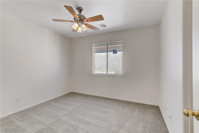 spare room with baseboards, visible vents, a ceiling fan, and light colored carpet