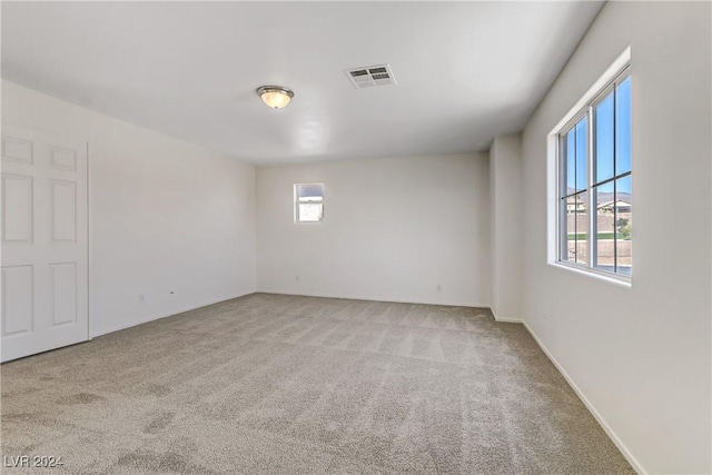 unfurnished room with visible vents and light carpet