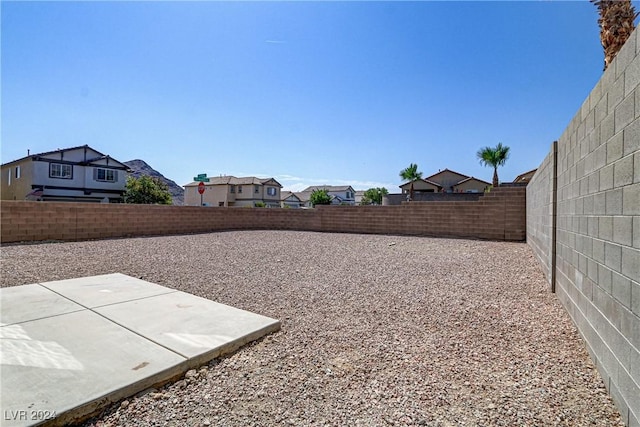 view of yard featuring a fenced backyard, a residential view, and a patio