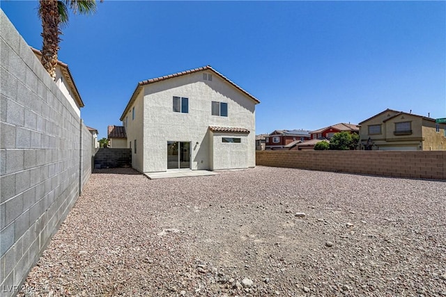 rear view of property with stucco siding, a fenced backyard, a residential view, and a patio