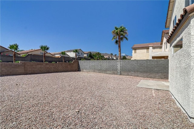 view of yard featuring a fenced backyard, a residential view, and a patio