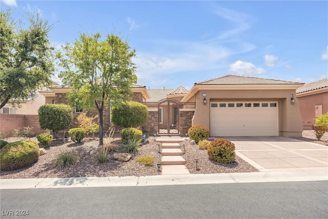 view of front of property with driveway, a tiled roof, an attached garage, and stucco siding