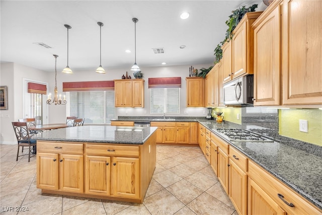 kitchen with sink, light tile patterned flooring, stainless steel appliances, and a kitchen island