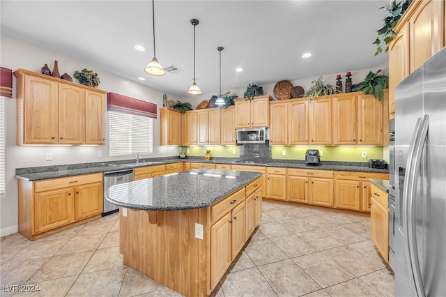 kitchen featuring stainless steel appliances, a center island, light tile patterned floors, sink, and decorative light fixtures