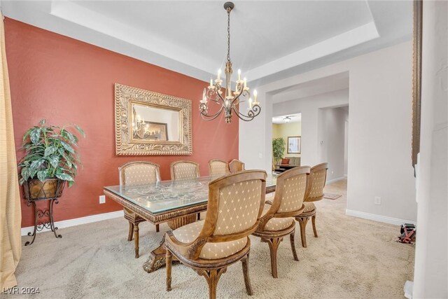 carpeted dining area with a notable chandelier and a raised ceiling