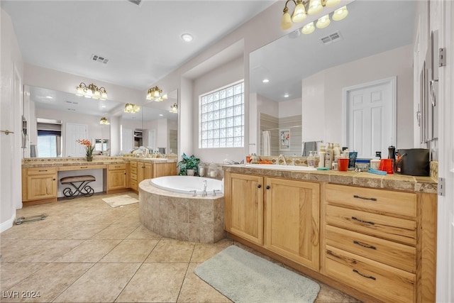 bathroom with vanity, tiled bath, and tile patterned flooring