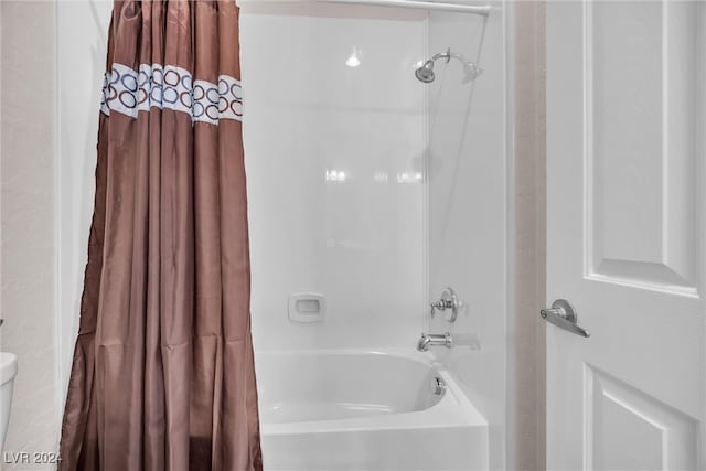 bathroom featuring shower / tub combo with curtain and toilet