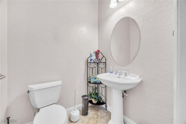 bathroom with toilet and tile patterned floors