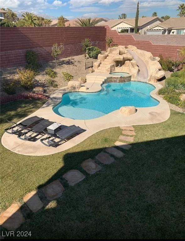 view of pool with a yard, a patio area, and an in ground hot tub