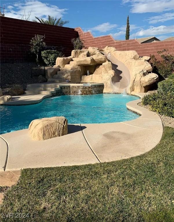 view of pool with pool water feature and a water slide