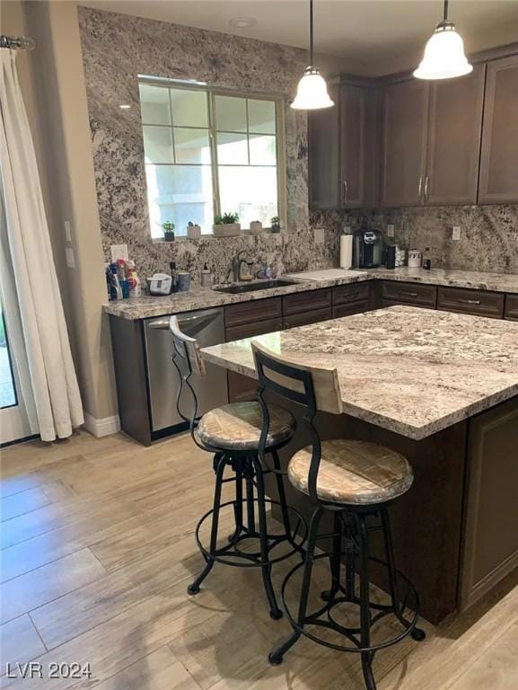 kitchen with pendant lighting, sink, dark brown cabinets, and dishwasher