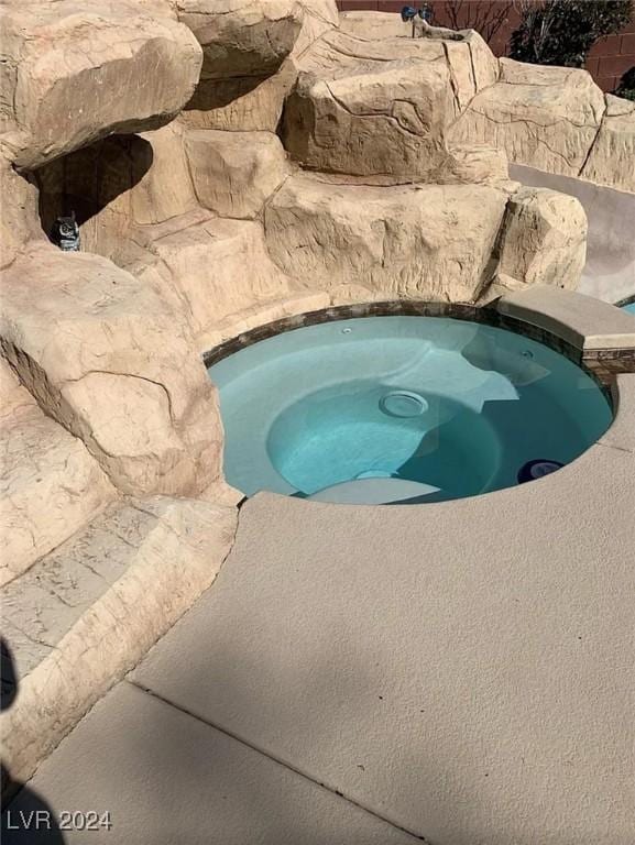 view of swimming pool featuring an in ground hot tub