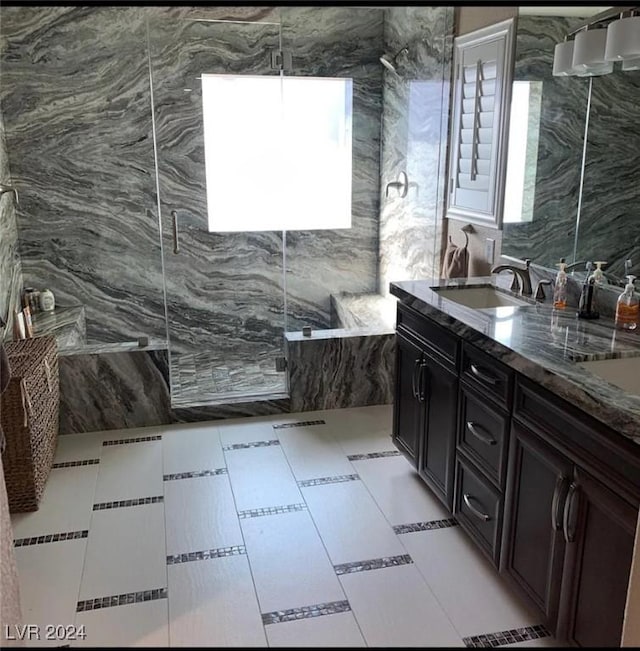 bathroom with vanity, a wealth of natural light, a shower with shower door, and tile walls