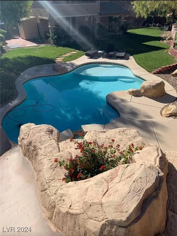 view of pool featuring a patio area and a lawn