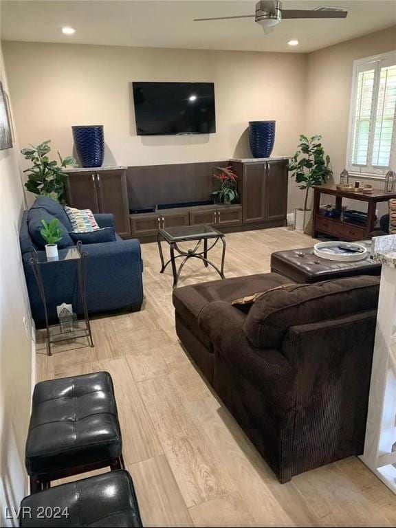 living room with light hardwood / wood-style flooring and ceiling fan