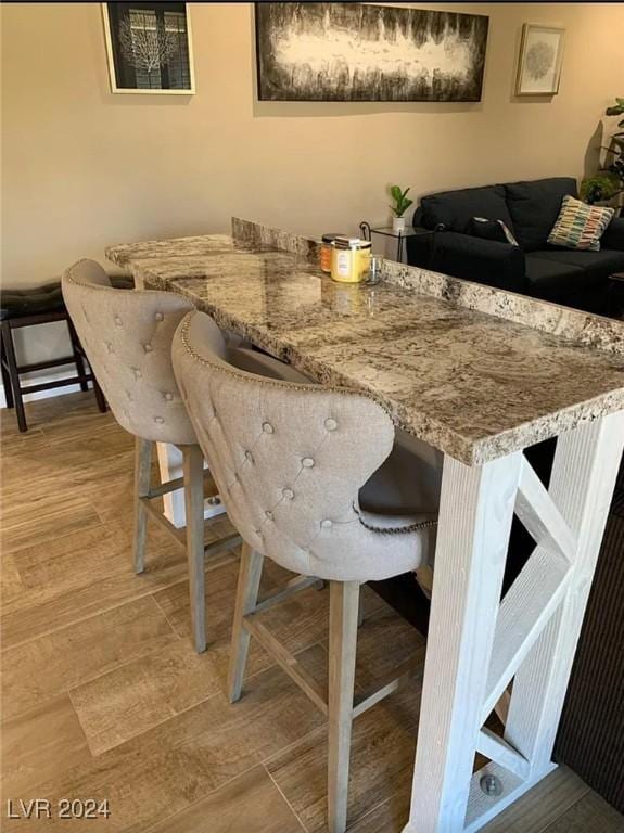 dining space with indoor bar and wood-type flooring