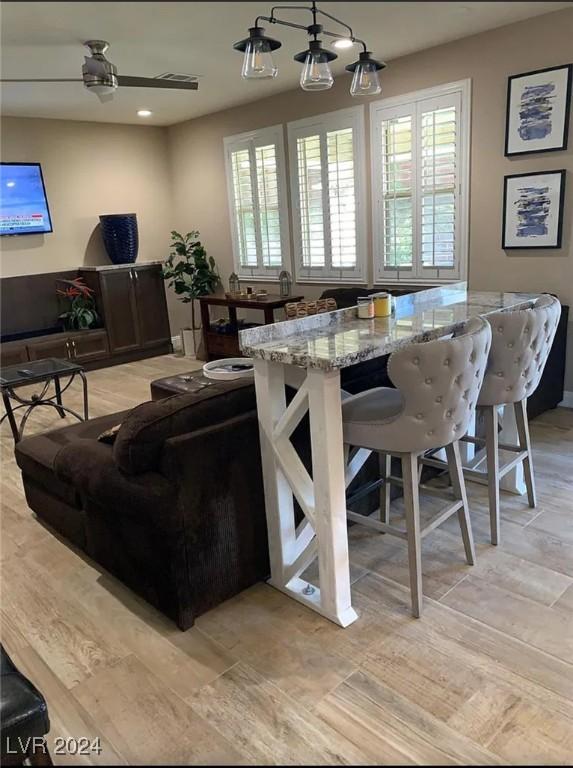 living room with ceiling fan and light hardwood / wood-style flooring