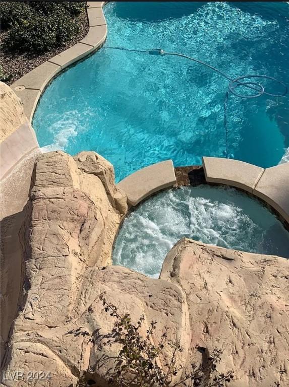 view of pool with an in ground hot tub