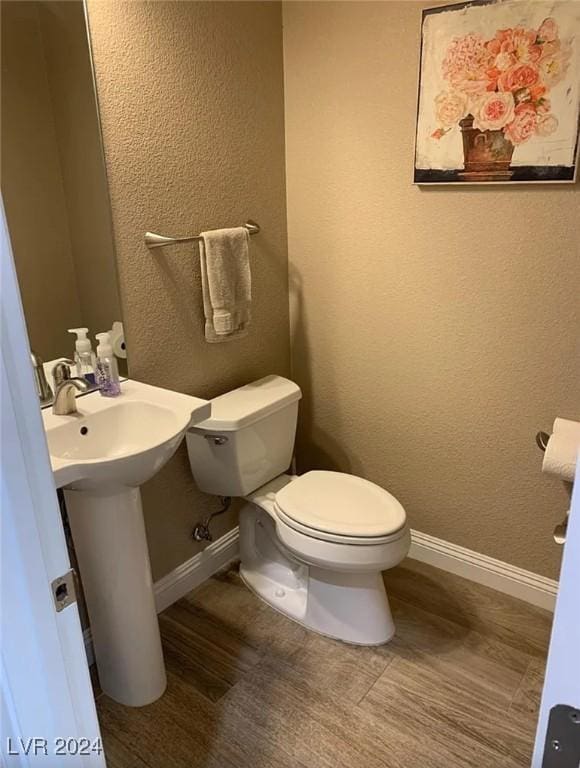 bathroom with toilet and hardwood / wood-style floors