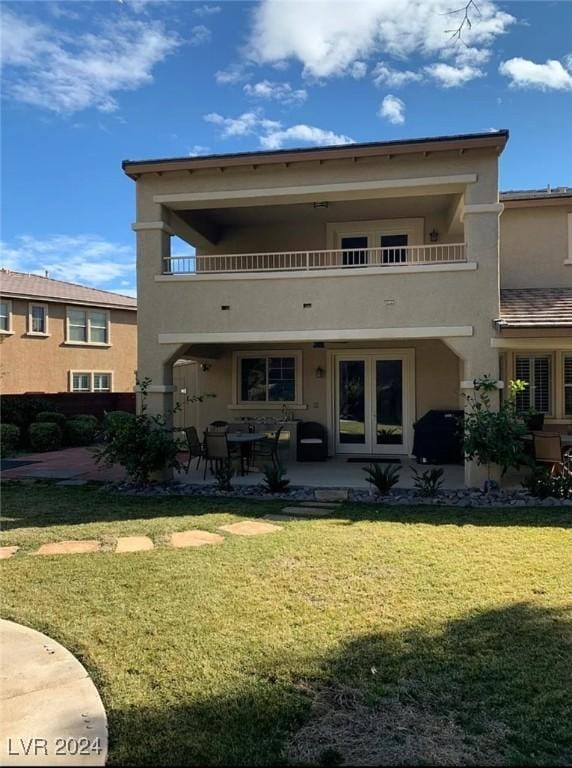 back of house with a lawn, a patio, and a balcony