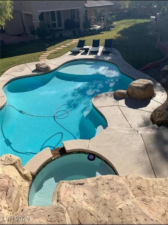 view of pool with an in ground hot tub