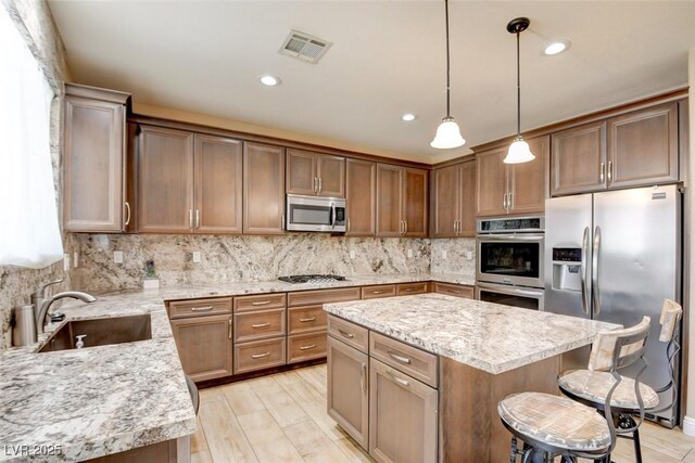 5301 Fairbranch Ln, Las Vegas, NV 89135 - kitchen featuring visible vents, decorative backsplash, a kitchen bar, a sink, and stainless steel appliances