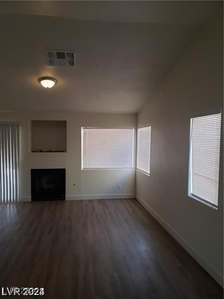 unfurnished living room featuring a wealth of natural light and hardwood / wood-style flooring