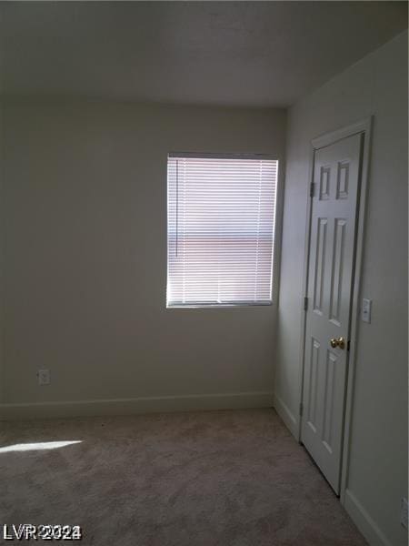 empty room with baseboards and carpet floors