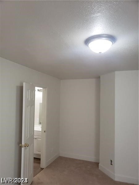 carpeted empty room featuring a textured ceiling