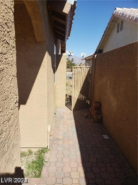 view of side of property featuring a tile roof, fence, and stucco siding