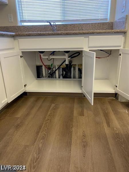 details with white cabinetry, dark stone counters, and dark wood-style flooring