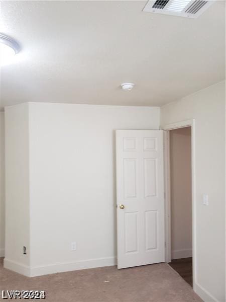 spare room with baseboards and visible vents