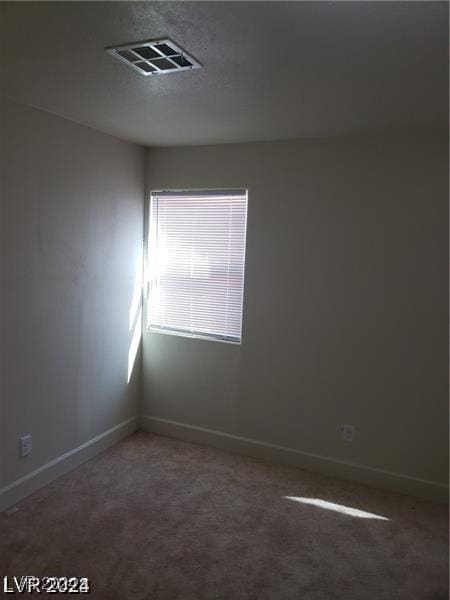 unfurnished room featuring baseboards, visible vents, and carpet floors