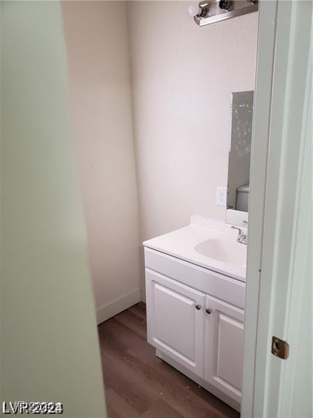 half bathroom featuring vanity and wood finished floors