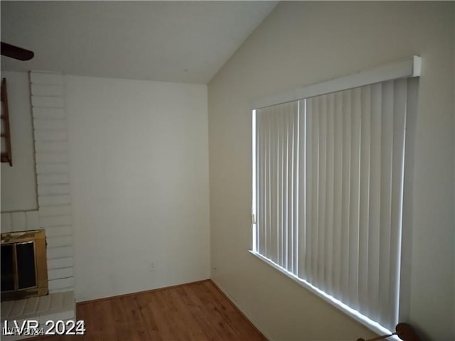 unfurnished living room featuring hardwood / wood-style flooring and lofted ceiling