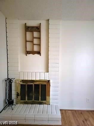 interior details featuring a brick fireplace and hardwood / wood-style floors