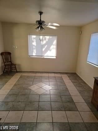 tiled empty room featuring ceiling fan