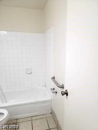 bathroom featuring tile patterned floors, bathtub / shower combination, and toilet