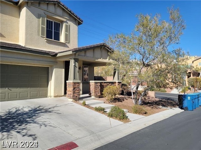 view of front of house featuring a tiled roof, stucco siding, driveway, and an attached garage