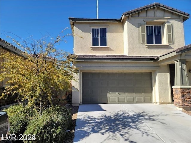 view of front facade with concrete driveway, an attached garage, and stucco siding