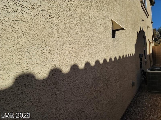 exterior details featuring central AC and stucco siding