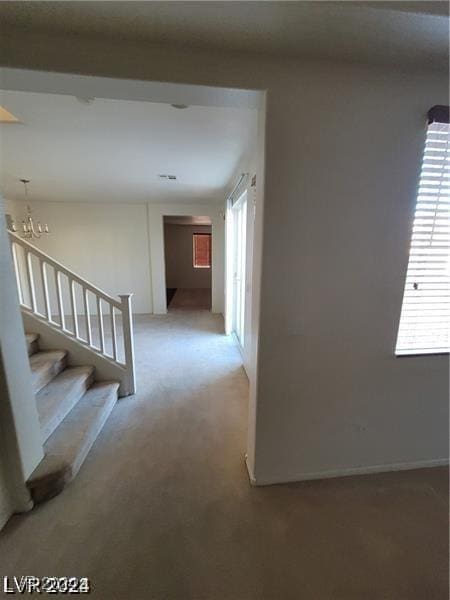 hall featuring light carpet and stairs