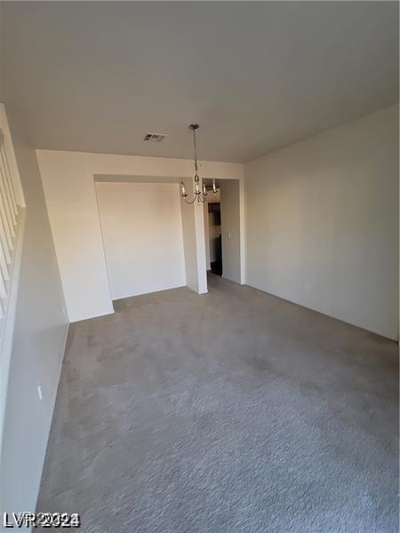 empty room featuring a notable chandelier and visible vents