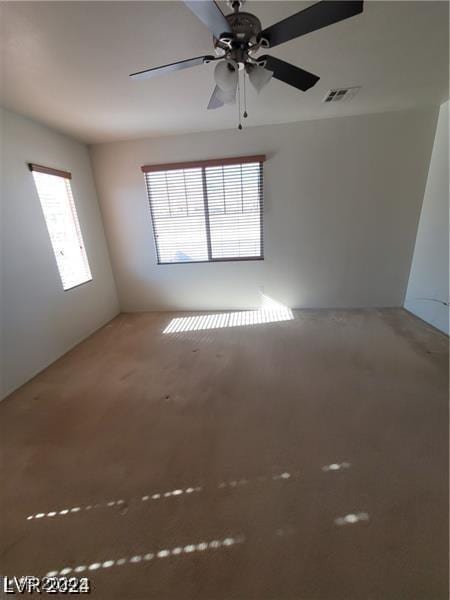 spare room featuring visible vents and ceiling fan