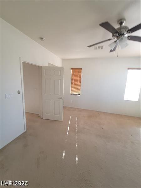 empty room with visible vents, a skylight, and a ceiling fan