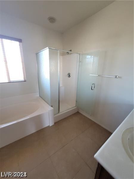 bathroom featuring tile patterned flooring, a bath, vanity, and a stall shower